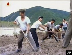 In this undated image from video distributed on Sept. 12, 2016, by North Korean broadcaster KRT, North Korean workers build levees along a river bank.
