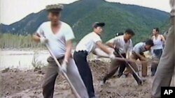 In this undated image from video distributed on Sept. 12, 2016, by North Korean broadcaster KRT, North Korean workers build levees along a river bank.