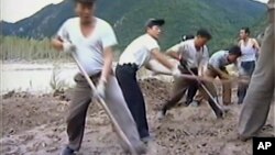 In this undated image from video distributed on Sept. 12, 2016, by North Korean broadcaster KRT, North Korean workers build levees along a river bank.