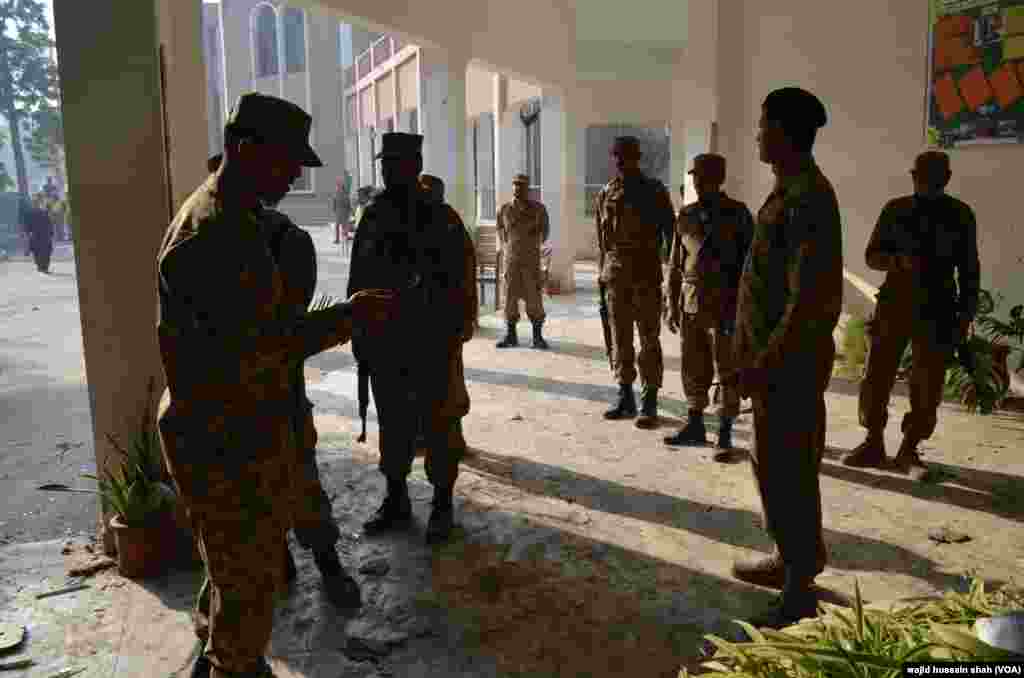 پشاور آرمی پبلک اسکول میں سکیورٹی فورسز کے اہلکار کھڑے ہیں۔