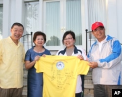 领队李素真(右二)致赠袁健生夫妇选手签名球衣。右一戴帽者为高雄市教育局局长蔡清华