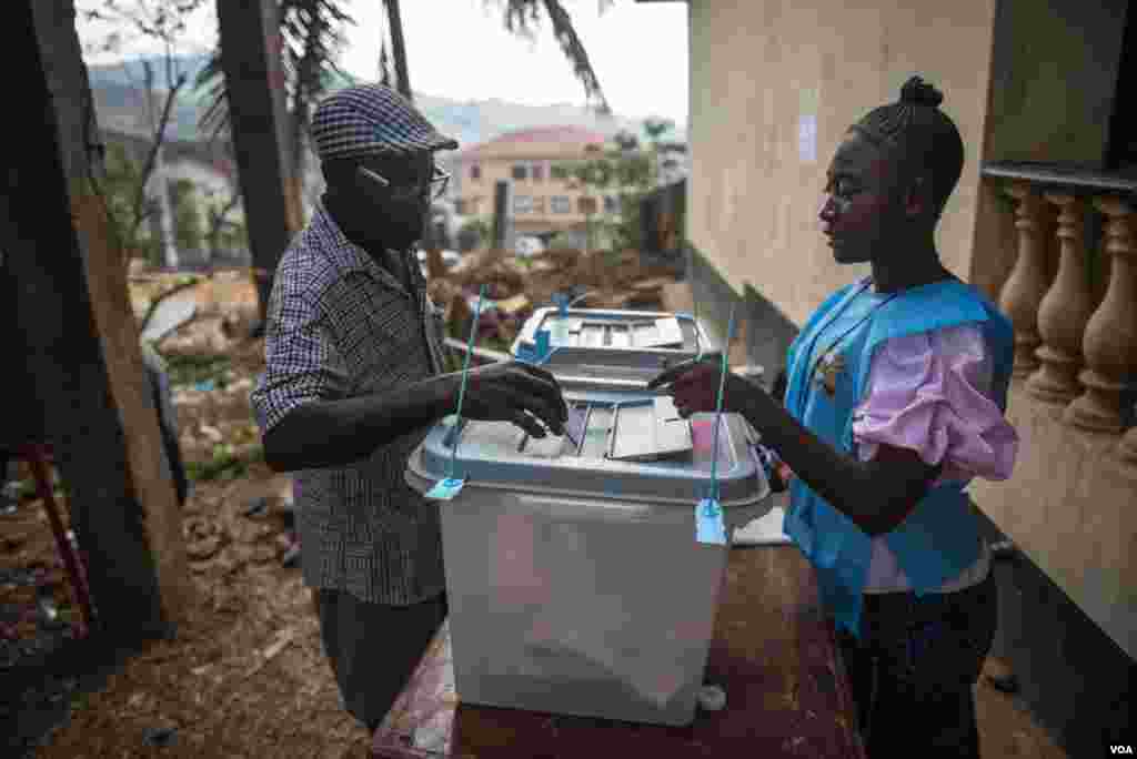 A voter casts his ballot at a polling station in Freetown, Sierra Leone, March 7, 2018. (Photo: Jason Patinkin / VOA) 