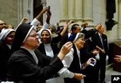 Nuns, some angered by the pushing and shoving, scramble to get into position for a photograph of the Pope as he leaves St. Patrick’s Cathedral, Sept. 24, 2015 in New York.