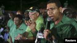 Andrew Holness (R), leader of the opposition Jamaican Labour Party, speaks to supporters at the party headquarters after they won the general election in Kingston, Jamaica, Feb. 25, 2016. 