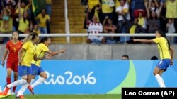 Brazil's Andressa Alves, right, celebrates with her teammates Fabiana, second left, and Marta, third left, after scoring her team's second goal during a Group E match of the Women's Olympic soccer tournament between Brazil and China.