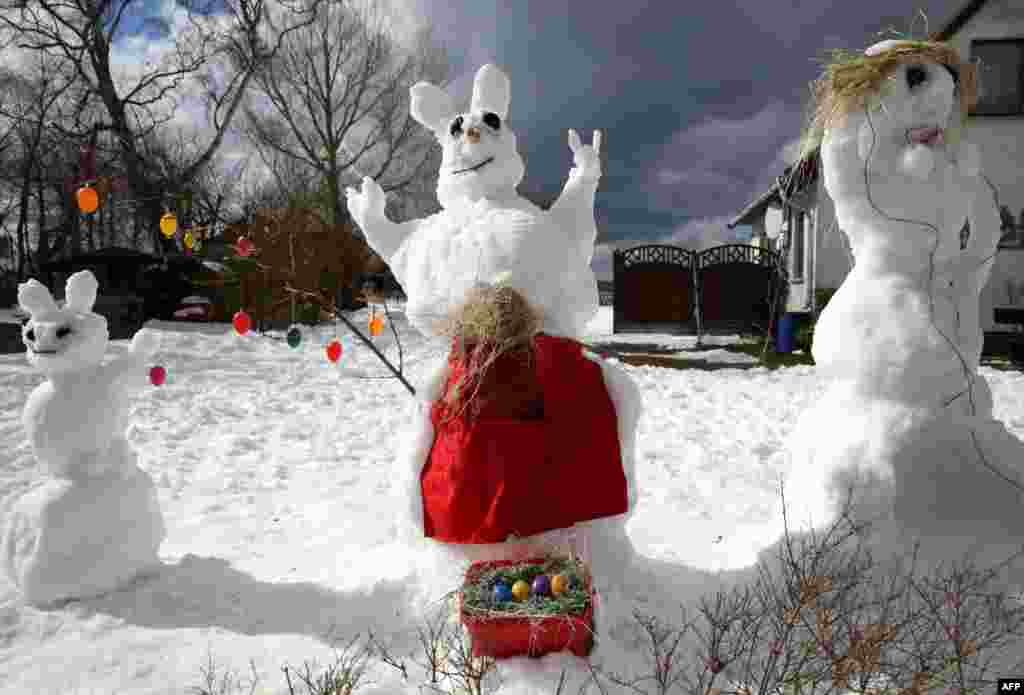 An Easter Bunny made out of snow is pictured on the side of the road to advertise rooms for rent in Ahrenshoop, Germany.