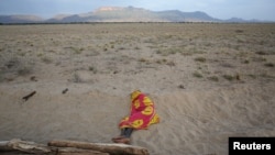 FILE - A Turkana man sleeps on the western shore of Lake Turkana close to Todonyang near the Kenya-Ethiopia border in northern Kenya, Sept. 25, 2014. 