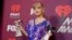 FILE - Taylor Swift poses in the press room with the awards for tour of the year for her "Reputation Stadium Tour" and best music video for "Delicate" at the iHeartRadio Music Awards, March 14, 2019, at the Microsoft Theater in Los Angeles. 