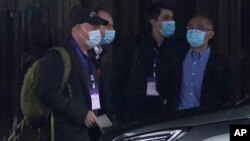 Members of the WHO team including Peter Daszak, left, Ken Maeda, right, and Vladimir Dedkov, second right, prepare to leave for a fourth day of field visits from their hotel in Wuhan in central China's Hubei province on Monday, Feb. 1, 2021. (AP Photo/Ng Han Guan)