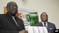 Director of Ivory Coast's Prime Minister Soro's Cabinet Paul Koffi (L) and president of Ivory Coast's Independent Electoral Commission (CEI) Youssouf Bakayoko (R) present the new provisional electoral list ahead of national elections in Abidjan, 12 Jul 20