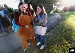 Students wait to be picked up after a shooting at Marjory Stoneman Douglas High School in Parkland, Fla., Feb. 14, 2018.