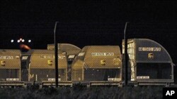 UPS cargo containers stand behind a security fence after they were searched by British police at the East Midlands airport, in Derby, England, 29 Oct 2010