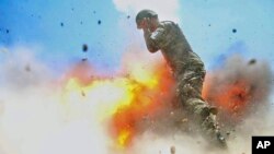 U.S Army combat camera photographer Spc. Hilda Clayton took this photo July 2, 2013 that was released by the U.S. Army, that shows an Afghan soldier engulfed in flame as a mortar tube explodes during an Afghan National Army live-fire training exercise.