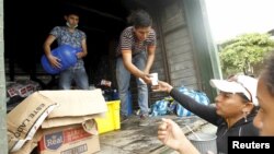Volunteers offer food and water to people in Pedernales, after an earthquake struck off Ecuador's Pacific coast, April 21, 2016. 