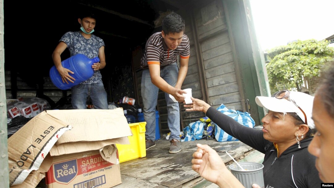 Volunteers offer food and water to people in Pedernales, after an earthquake struck off Ecuador's Pacific coast, April 21, 2016. 