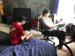 Dora Mekouar's sons, unexpectedly home from college, are now taking their final exams online. (Dora Mekouar/VOA)