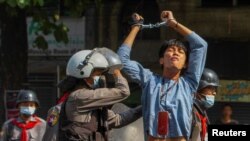 A pro-democracy protester is detained by riot police officers during a rally against the military coup in Yangon, Myanmar, February 27, 2021. 