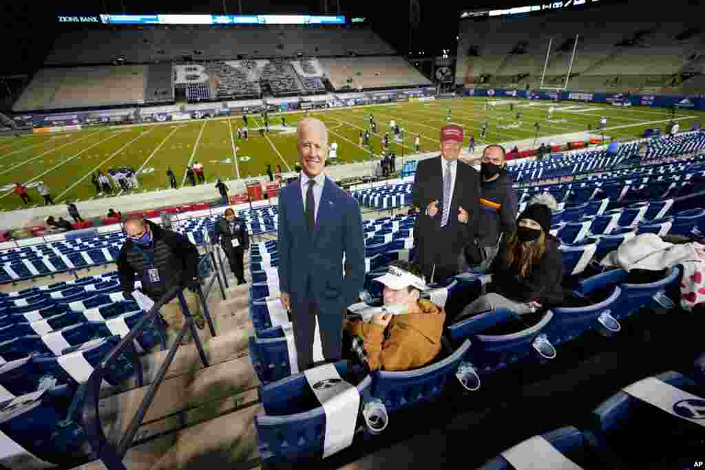 BYU fans hold up cardboard cutouts of Democratic presidential candidate former Joe Biden and President Donald Trump before an NCAA college football game between BYU and Western Kentucky, Oct. 31, 2020, in Provo, Utah.