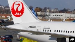 FILE - A Japan Airlines Boeing 787 Dreamliner jet surrounded by emergency vehicles at Logan International Airport in Boston.