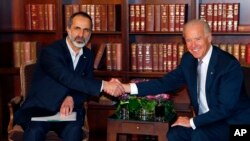 US Vice President Joe Biden, right, and Sheikh Moaz al-Khatib, Syria's top opposition leader, shake hands at the Security Conference in Munich, Germany, February 2, 2013.