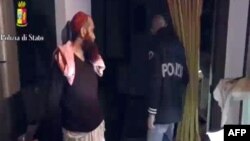 This screen grab taken from a video released on April 24, 2015 by the Italian police shows a man (L) suspected to be a member of an armed organization inspired by al-Qaida and other radical organisations. 