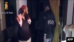 FILE - This screen grab taken from a video released on April 24, 2015 by the Italian police shows a man (L) suspected to be a member of an armed organization inspired by al-Qaida and other radical organizations. 
