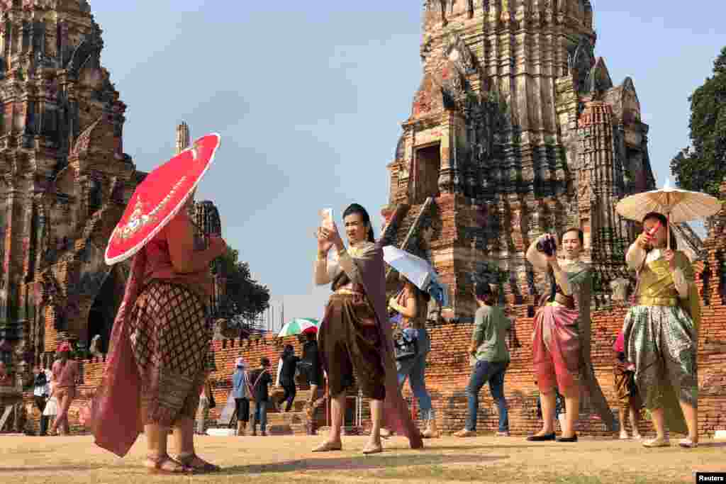 People dressed in traditional costumes pose for a picture, as interest for historical clothing rises within the country, in Ayutthaya, Thailand.