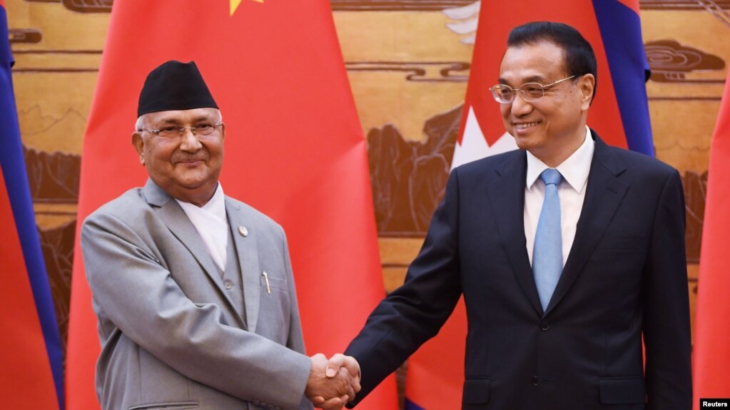 中国国务院总理李克强与来访的尼泊尔总理奥利在人民大会堂签字仪式上握手(2018年6月21日路透社)