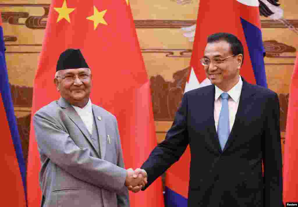中国国务院总理李克强与来访的尼泊尔总理奥利在人民大会堂签字仪式上握手（2018年6月21日）。奥利是第二次担任总理。他是尼泊尔共产党两位主席之一，被认为亲北京。