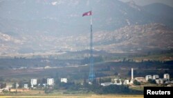 Sebuah bendera Korea Utara terlihat berkibar di atas sebuah menara dekat desa Panmunjom di zona demiliterisasi (DMZ) yang memisahkan Korea Utara dan Kores Selatan, 55 kilometer dari kota Seoul (Foto: REUTERS/Lee Jae-Won).