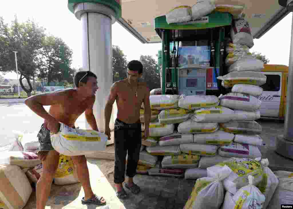 Men reinforce a petrol station with sacks of sand in Donetsk, Aug. 13, 2014.