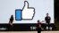 FILE - Visitors take photos in front of the Facebook logo at the company's headquarters, March 28, 2018, in Menlo Park, Calif.