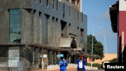 Men wearing protective masks walk down a deserted street on the first day of the 21-day nationwide lockdown aimed at limiting the spread of coronavirus disease (COVID-19) in Harare, Zimbabwe, March 30, 2020.