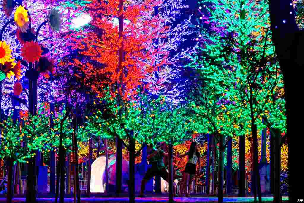 A Malaysian couple poses for pictures amid a forest of LED lights at an amusement park in Kuala Lumpur.