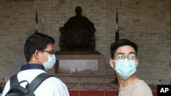 People wear face masks to protect against the spread of the new coronavirus at Chiang Kai-shek Memorial Hall in Taipei, Taiwan, Thursday, Feb. 27, 2020.