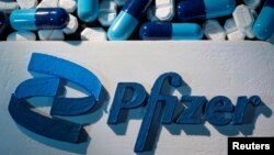 Logo de Pfizer junto a medicamentos fabricados por la compañía.