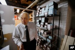 Peter Stefan, funeral director and proprietor of the Graham Putnam & Mahoney Funeral Parlor, stands in front of shelves holding the cremated remains of unclaimed bodies dating back more then a decade, in the basement of the Graham Putnam & Mahoney Funeral Parlor in Worcester, Massachusetts, Feb. 1, 2018.