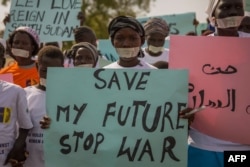 FILE - Women from more than 40 South Sudanese women's organizations carry placards as they march through Juba to highlight the frustration and suffering women and children have been enduring during years of conflict, in Juba, South Sudan, Dec. 9, 2017.