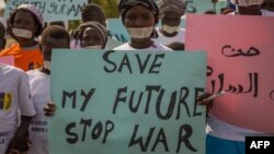 FILE - Women from more than forty South Sudanese womens organizations carry placards as march through Juba to express the frustration and suffering that women and children have endured after years of conflict, in Juba, South Sudan on Dec. 9, 2017. 