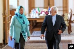 FILE - Iranian Foreign Minister Mohammad Javad Zarif and European Union foreign policy chief Federica Mogherini arrive to attend a press briefing after their meeting in Tehran, Iran, April 16, 2016.