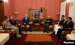 FILE - Afghanistan's President Ashraf Ghani (R) and U.S. special envoy for peace in Afghanistan, Zalmay Khalilzad (L), meet in Kabul, Afghanistan, Nov. 10, 2018. (Presidential Palace/Handout via Reuters)