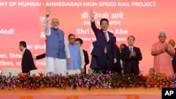 Japanese Prime Minister Shinzo Abe, right and Indian Prime Minister Narendra Modi wave during the ground breaking ceremony for high speed rail project in Ahmadabad, India, Sept. 14, 2017. 