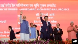 Japanese Prime Minister Shinzo Abe, right and Indian Prime Minister Narendra Modi wave during the ground breaking ceremony for high speed rail project in Ahmadabad, India, Sept. 14, 2017. 