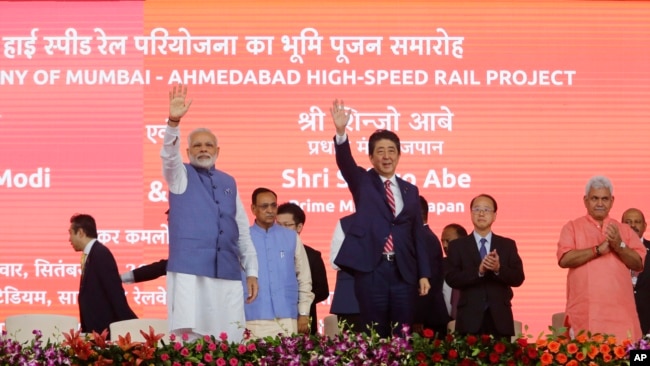 Japanese Prime Minister Shinzo Abe, right and Indian Prime Minister Narendra Modi wave during the ground breaking ceremony for high speed rail project in Ahmadabad, India, Sept. 14, 2017. 
