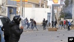 Des manifestants lancent des projectiles contre les forces de l’ordre dans la ville d’Ennour, Tunisie. 20 janvier 2016. 