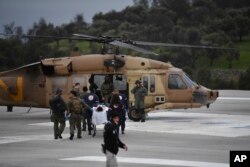 FILE - An Israeli medical team evacuate a person injured by a rocket fired from Lebanon, at Ziv hospital in Safed, northern Israel, February 14, 2024.