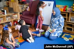 Guru prasekolah, Tinhinane Meziane, mengarahkan siswa memilih karakter terpopuler PAW Patrol di ACCA Child Development Center, Kamis, 19 September 2024, Annandale, AS. (John McDonnell/AP)