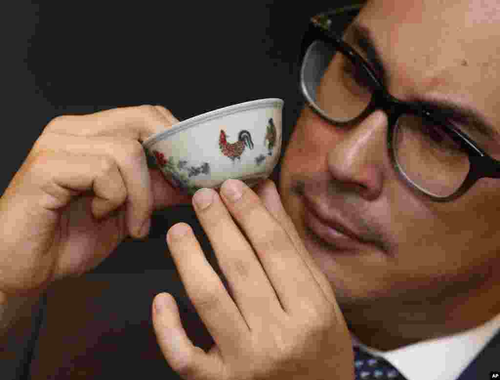 홍콩의 소더비 경매소에서 한 직원이 중국 명나라 시대의 닭 문양 잔을 소개하고 있다. 이 잔은 미화 2천560만 달러에서 3천860만 달러에 거래될 것으로 예상된다.
