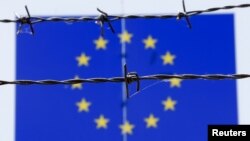 Žica ispred zastave Evropske unije u imigracionom centru u Mađarskoj