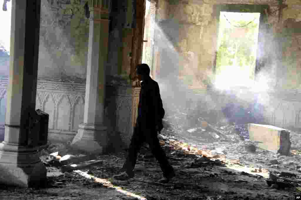 An Egyptian walks among the burned remains of the Rabaah al-Adawiya mosque, in the center of a camp of Morsi supporters that was cleared by security forces, Nasr city, Cairo, August 15, 2013.